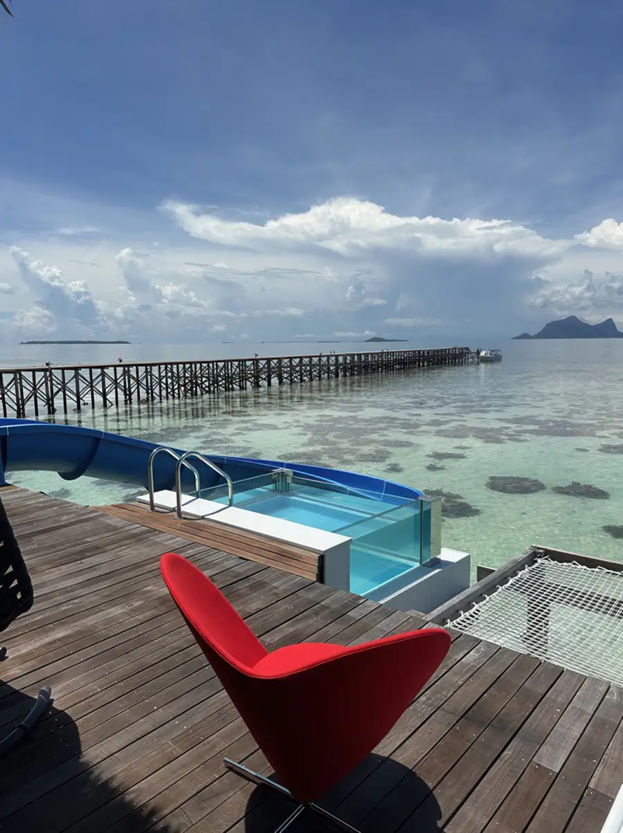 Sun-drenched private deck with a glass-sided plunge pool at Cupid Resort, offering sweeping views across the Semporna archipelago.