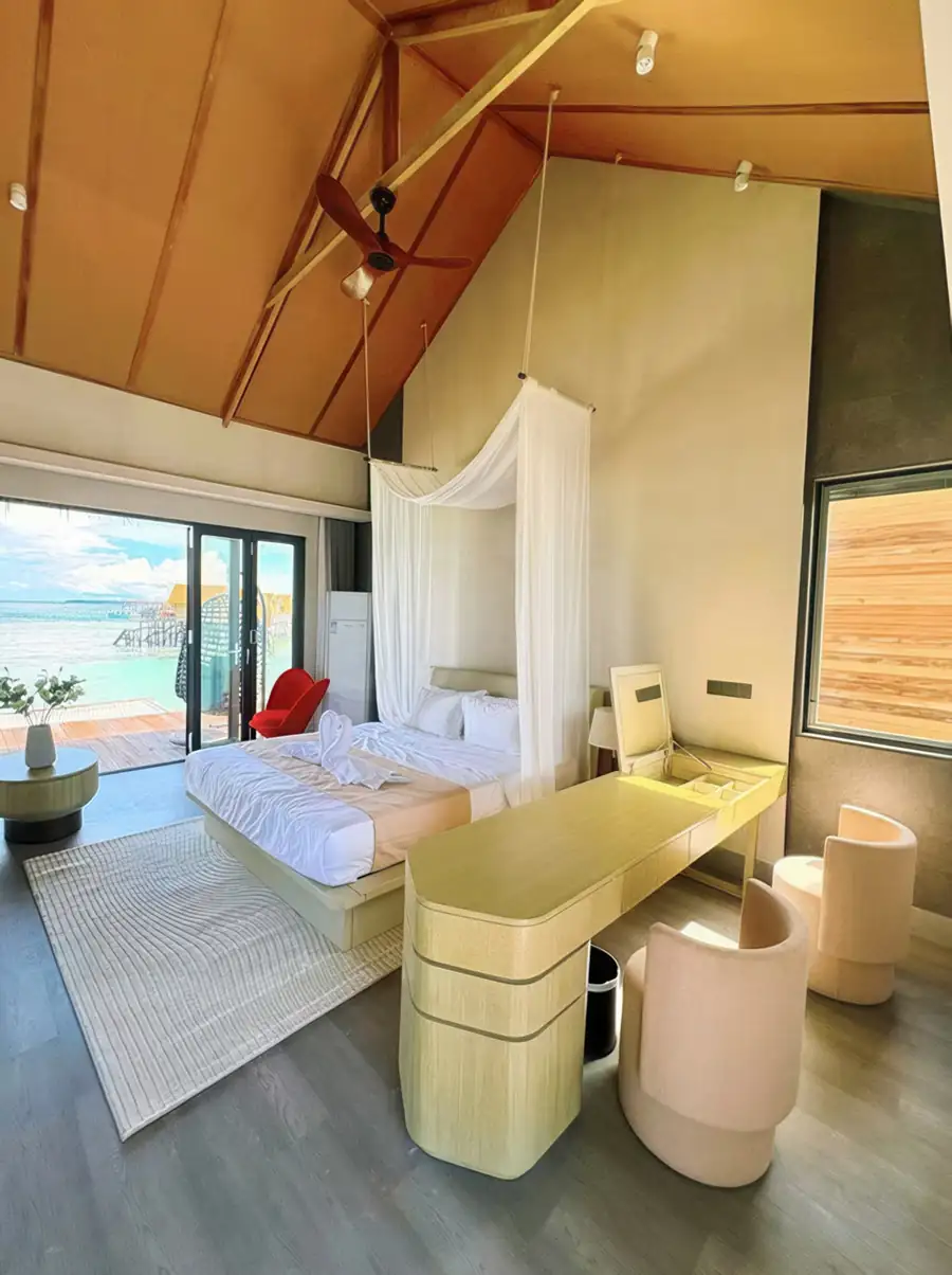 A distinctive bedroom at Cupid Resort over the Celebes Sea featuring a king size bed, classic wood floors, AC, and large oceanview windows.