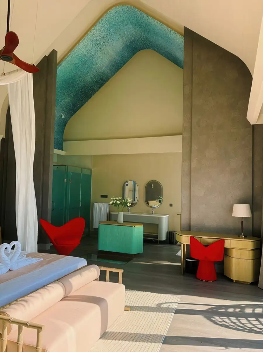 A stylish bedroom suite at Cupid Resort in Semporna featuring a modern workspace, sleek vanity mirrors, gleaming timber floors, and air con.